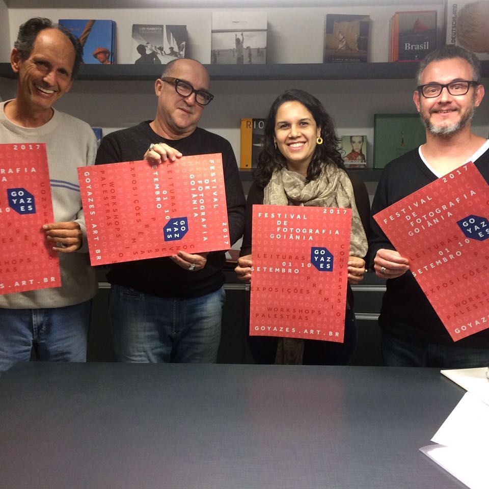 Quatro pessoas seguram cartazes do Festival de Fotografia de Goiânia de 2017.